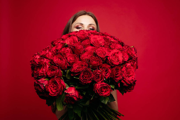 Selective focus of bouquet of red roses in hands of woman - Photo, image