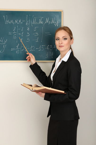 Portrait of teacher woman near the chalkboard in classroom - Valokuva, kuva