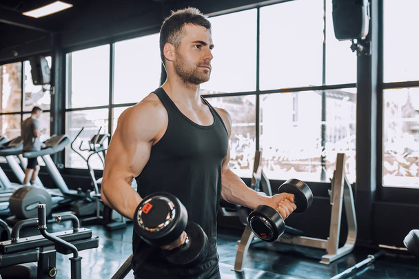 Hombre musculoso guapo haciendo ejercicio en el gimnasio
 - Foto, imagen