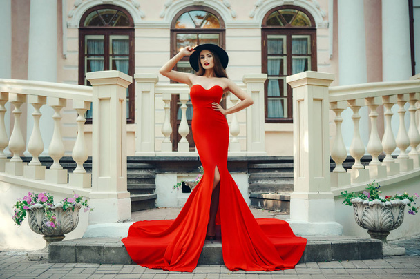 Όμορφη κοπέλα ποζάρει σε ένα σέξι κόκκινο φόρεμα - Φωτογραφία, εικόνα