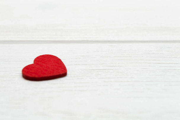 Red wooden heart on white wooden background. Valentine's day or Love concept. - Φωτογραφία, εικόνα