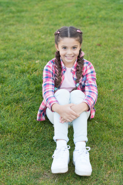 Pleasant walk in park. Smile and joy. Fashionable hairstyle for kids. Girl small kid with fashionable braids hairstyle. Charming smile. Fashion trend. Salon and hair care. Girl smile face outdoors - Valokuva, kuva