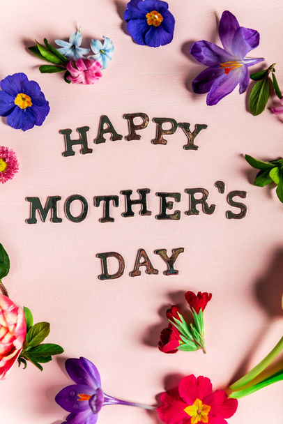 Boldog anyák napja különböző tavaszi virágok körül őket betűket - Fotó, kép