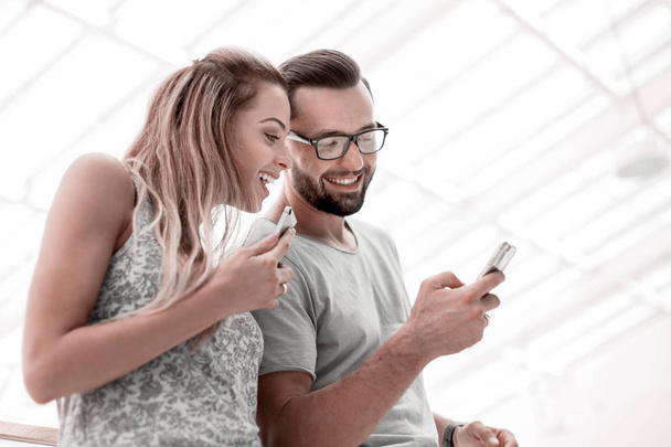 Riendo pareja viendo fotos en el teléfono inteligente
 - Foto, imagen