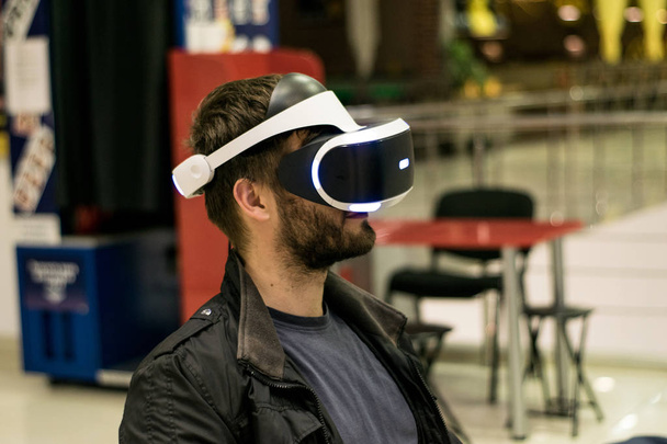 człowiek w słuchawkach VR, który cieszy się grą. Wirtualna rzeczywistość. mężczyzna w zestawie słuchawkowym VR z joystickami - Zdjęcie, obraz