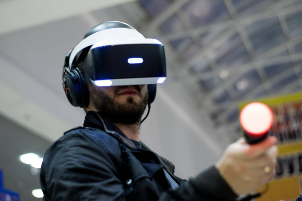 людина в гарнітурі VR, яка насолоджується грою. Віртуальна реальність. людина в гарнітурі VR з джойстиками - Фото, зображення
