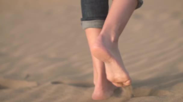 Yakın çekim, yavaş hareket. Altın kum plaj üzerinde yürüyen kadın ayaklar. - Video, Çekim