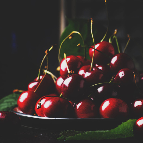 Red sweet cherries on brown kitchen table background, still life, selective focus - Zdjęcie, obraz