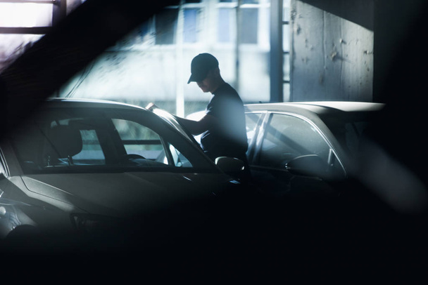 Carjacker unlocking vehicle in garage - Photo, image
