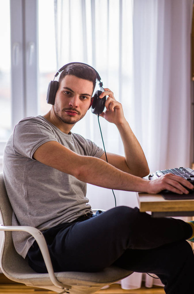 Homem com fones de ouvido trabalhando no PC
  - Foto, Imagem