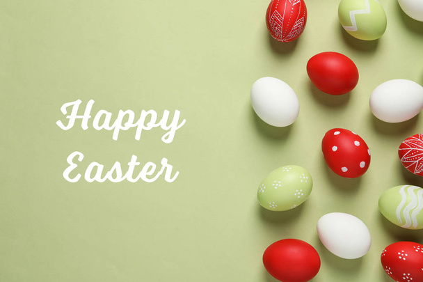 Flat lay composition with painted eggs and text Happy Easter on color background - Photo, Image