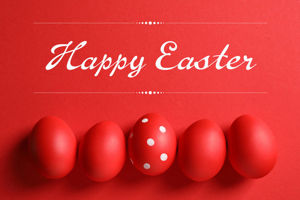 Flat lay composition of red painted eggs and text Happy Easter on color background - Φωτογραφία, εικόνα