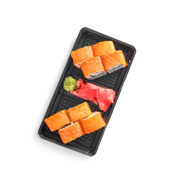 Box with tasty sushi rolls on white background, top view. Food delivery - Photo, image