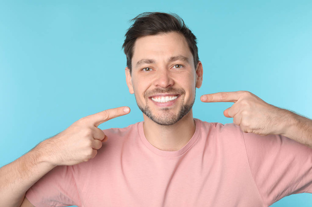 Smiling man with perfect teeth on color background - Fotografie, Obrázek