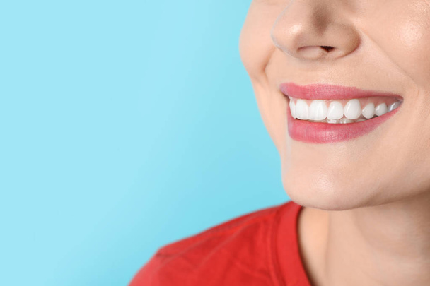 Smiling woman with perfect teeth on color background, closeup. Space for text - Фото, изображение