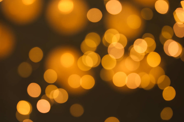 Blurred view of gold lights on dark background. Bokeh effect - Foto, Imagem