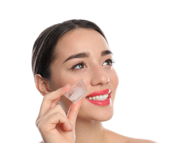 Young woman with ice cube on white background. Skin care - Foto, Imagen
