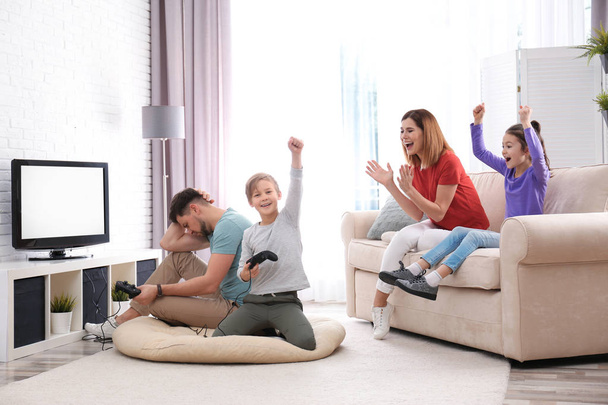 Happy family playing video games in living room - Foto, Imagen