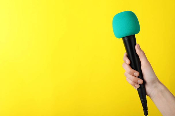 Woman holding microphone on color background, space for text - Fotoğraf, Görsel