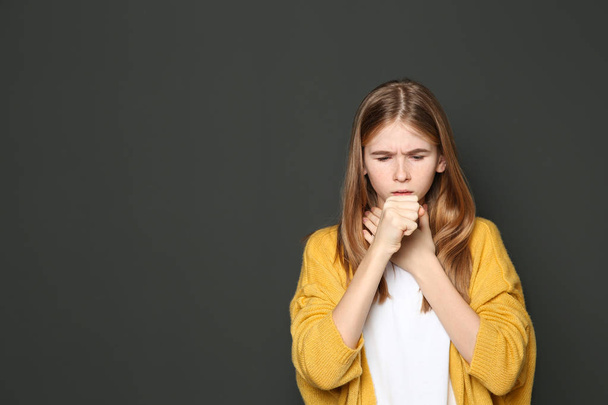 Teenage girl suffering from cough on dark background. Space for text - Fotoğraf, Görsel