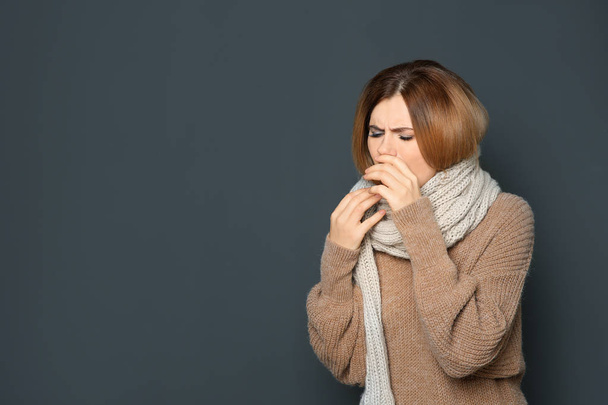 Woman suffering from cough on dark background. Space for text - Photo, Image