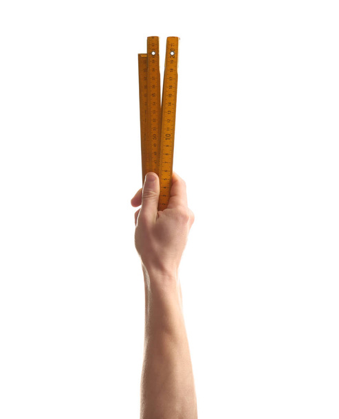 Man holding ruler on white background. Construction tools - Foto, afbeelding