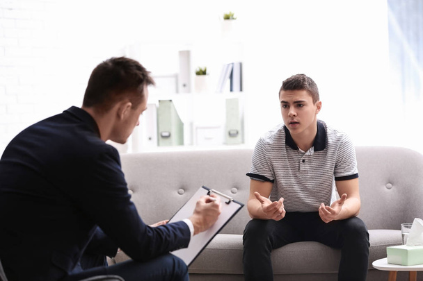 Psychotherapist working with young man in office - Foto, Imagem