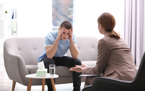 Psychotherapist working with young man in office - Fotó, kép