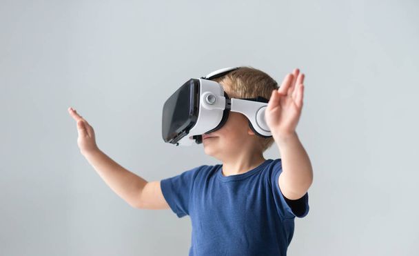 Portrait of happy boy in a virtual reality headset. Attractive kid using vr goggles at home. Entertainment technology and generation Z concept. - Foto, Bild