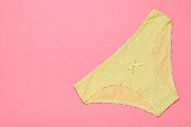 Žluté bavlněné dámské kalhotky na žlutém podkladu. Módní pojem. Krásné spodní prádlo. - Fotografie, Obrázek