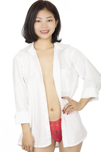 Chinese woman dressed in red thong isolated on white background - 写真・画像