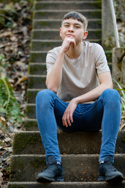 Teini-ikäinen poika ulkona kirkkaana kevätpäivänä
 - Valokuva, kuva