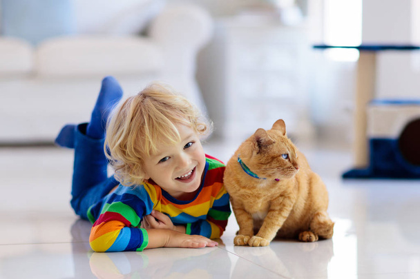 Gyermek játszó macska otthon. Gyerekek és pets. - Fotó, kép