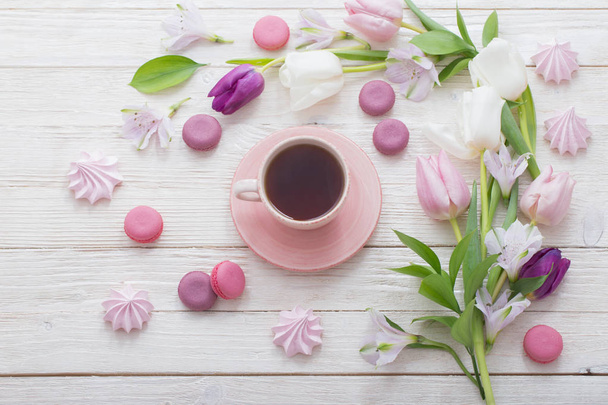 Tulips  and cup of coffee with dessert on white background. Conc - Foto, imagen