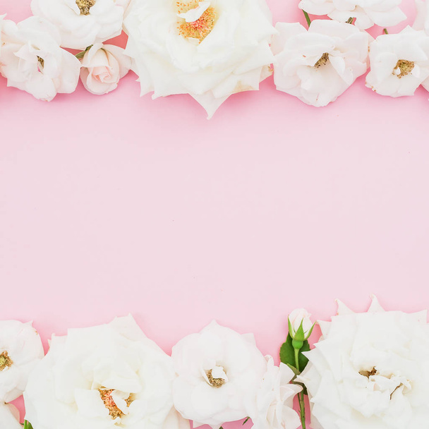 Frame of white roses on pastel pink background. Flat lay, top view. - Foto, Imagem