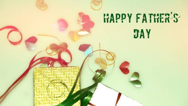 Joyeuses paroles de la fête des pères avec un petit cœur coloré en forme et des boîtes cadeaux comme arrière-plan
. - Photo, image