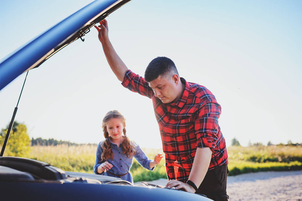 father and daughter fixing problems with car during summer road trip. Kid girl helping dad. - Photo, image
