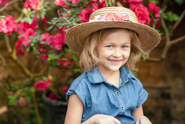 Toddler with flower basket. girl holding pink flowers - Фото, зображення