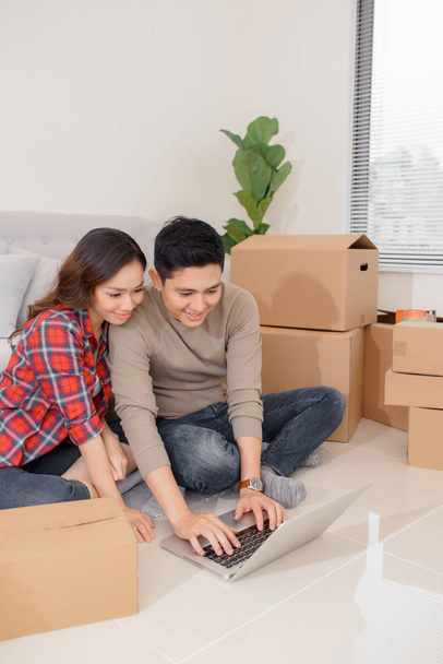 Young couple moving in a new home. Man and woman with notebook l - Фото, изображение