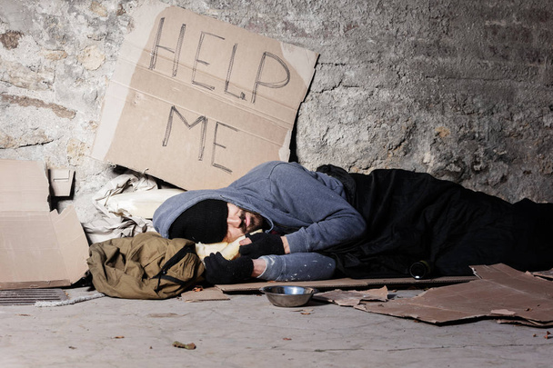 Uomo mendicante in vecchi vestiti che dorme per strada
 - Foto, immagini