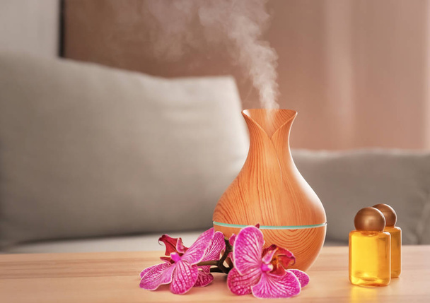 Difusor de óleo de aroma com garrafas na mesa no quarto
 - Foto, Imagem