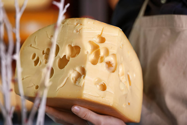 Αρσενικό πωλητή με νόστιμα τυριά στο κατάστημα, κοντινό πλάνο - Φωτογραφία, εικόνα