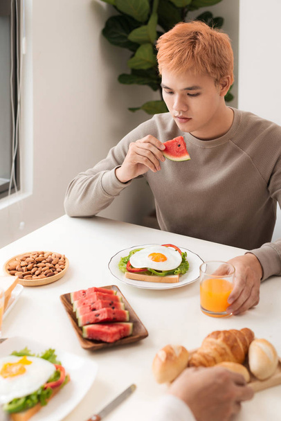 Мужчины завтракают с тостами за столом
 - Фото, изображение
