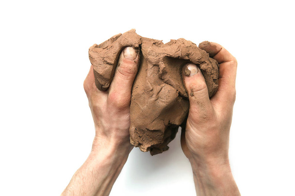 Natural clay piece in hands  isolated on white background.  Wet clay material for sculpting or modeling. - Valokuva, kuva