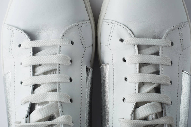 Top view of female white sneakers on black background. Closeup. - Foto, Bild