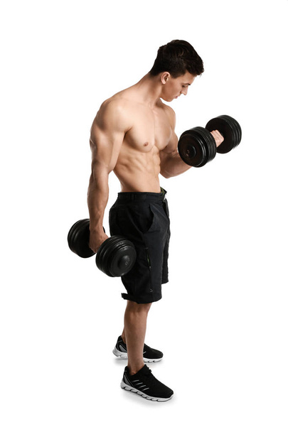 Muscular bodybuilder with dumbbells on white background - Foto, imagen