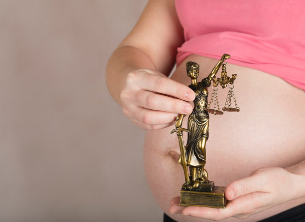 junge schwangere Frau behält Statue der Themis.  - Foto, Bild