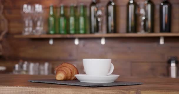 Colpo da vicino di un croissant sullo stesso vassoio con una tazza di caffè
 - Filmati, video