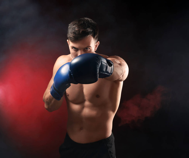 Houkutteleva nuori nyrkkeilijä tummalla taustalla
 - Valokuva, kuva
