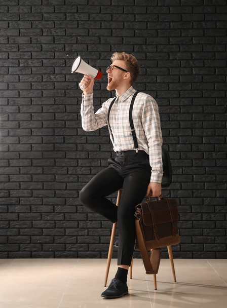 Ουρλιάζοντας επιχειρηματίας με μοντέρνα χαρτοφύλακα κοντά σκοτεινό τούβλο τοίχο - Φωτογραφία, εικόνα